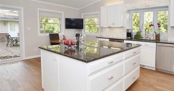 Finished white kitchen cabinetry with dark countertops